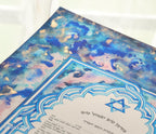 Jewish ketubah handmade for chuppah jewish wedding maroccan style with blue and white magen David colors like the Talith. Watercolor painting handmade ketubbah with sunset colors in maroccan style, unique one of a kind wedding ketubbah piece of jewish art made in israel by designer ketubbah. Illustrated blue, pink and white ketubah with sunset colors and blue and white colors around the text to remember blue colors of Am Israel.