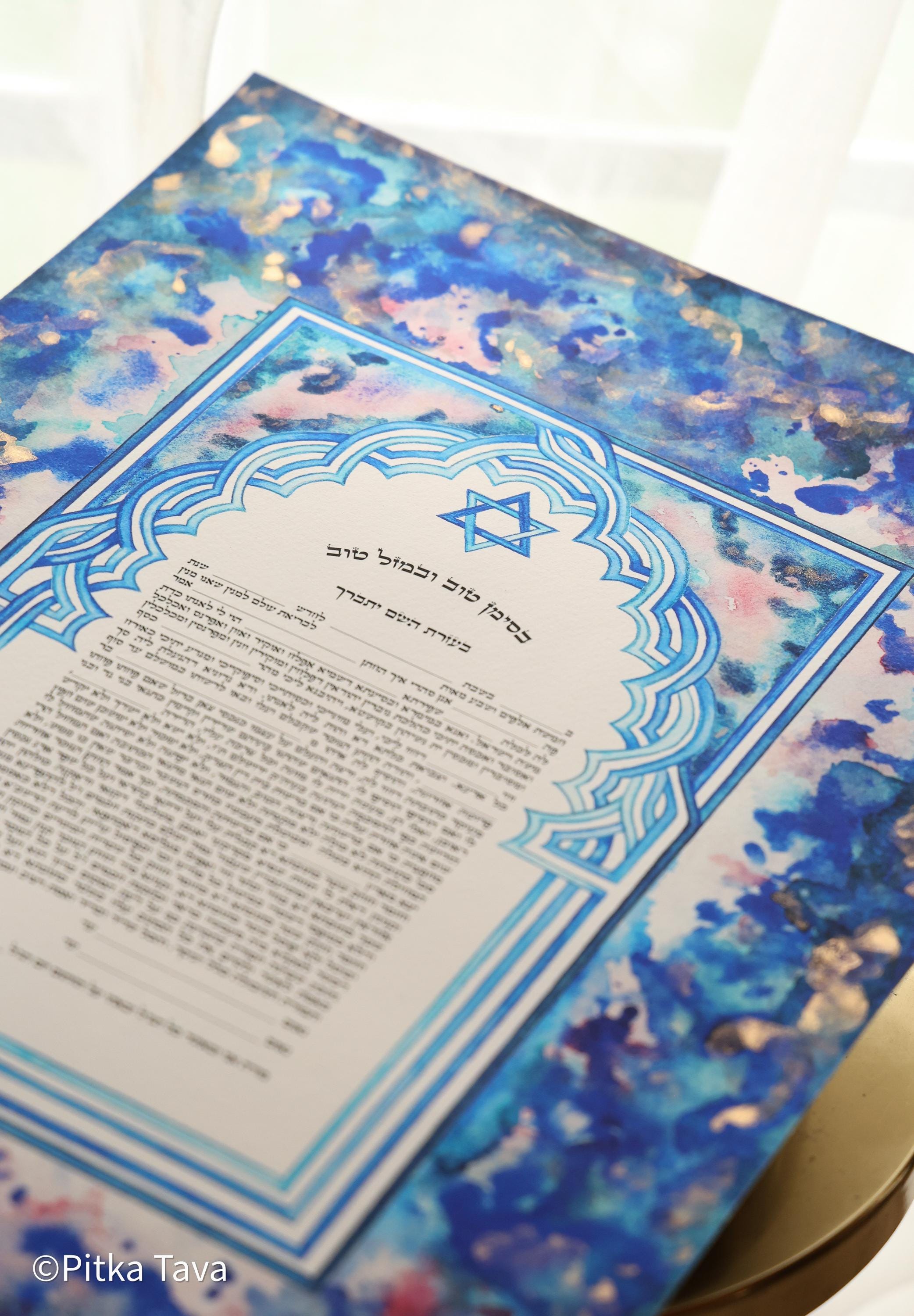 Jewish ketubah handmade for chuppah jewish wedding maroccan style with blue and white magen David colors like the Talith. Watercolor painting handmade ketubbah with sunset colors in maroccan style, unique one of a kind wedding ketubbah piece of jewish art made in israel by designer ketubbah. Illustrated blue, pink and white ketubah with sunset colors and blue and white colors around the text to remember blue colors of Am Israel.